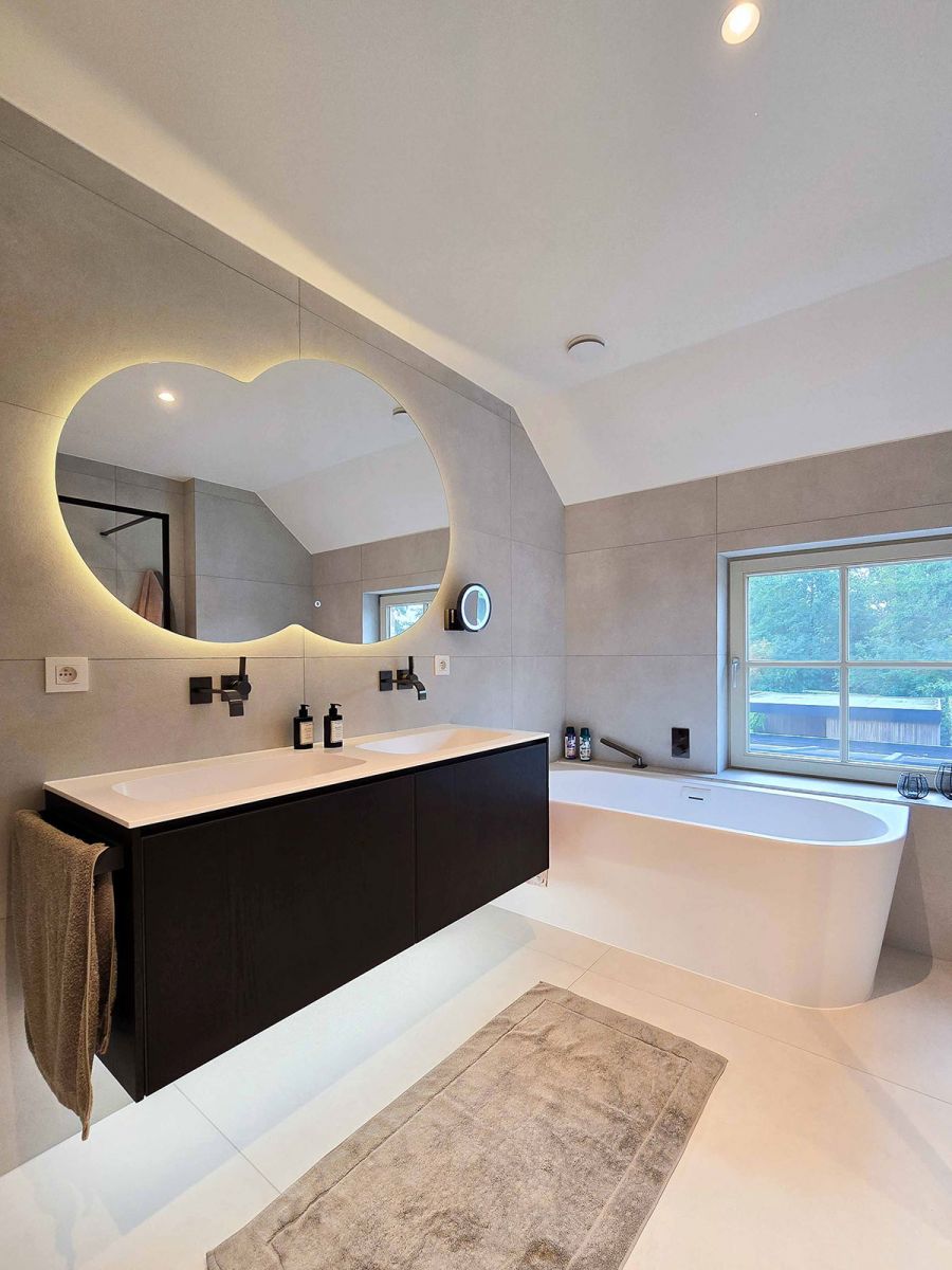 Opgeleverde badkamer met moderne ronde spiegels met verlichting Opgeleverde badkamer met moderne ronde spiegels met verlichting