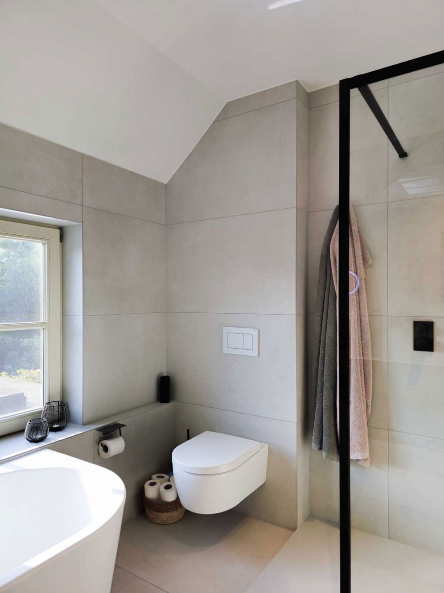 Badkamer met inloopdouche, hangtoilet en ligbad Badkamer met inloopdouche, hangtoilet en ligbad